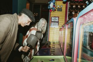 Smiling couple enjoying whack a mole, which is what you do if you don't do due diligence