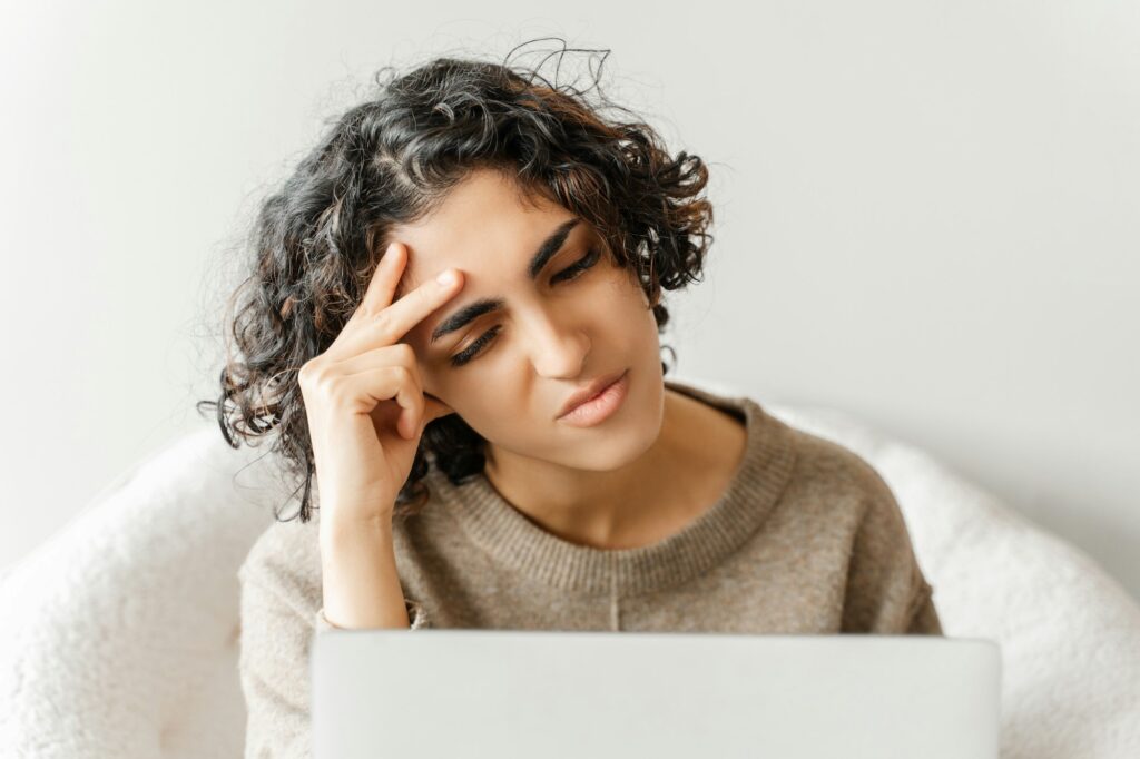 Stressed tired middle eastern woman using laptop computer searching information