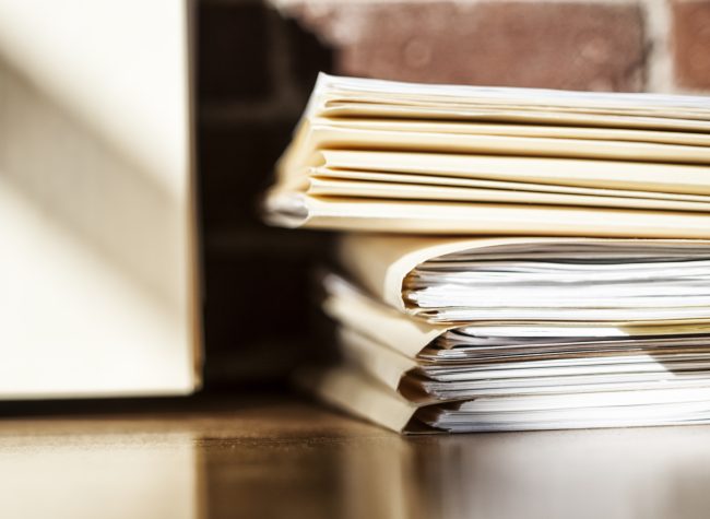 Close-up of due diligence files and file folders on a desk top in an office.